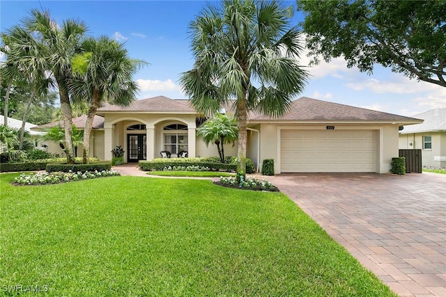 2322 River Reach Dr, Naples, FL 34104 - view of front of home with decorative driveway, a front lawn, an attached garage, stucco siding, and french doors
