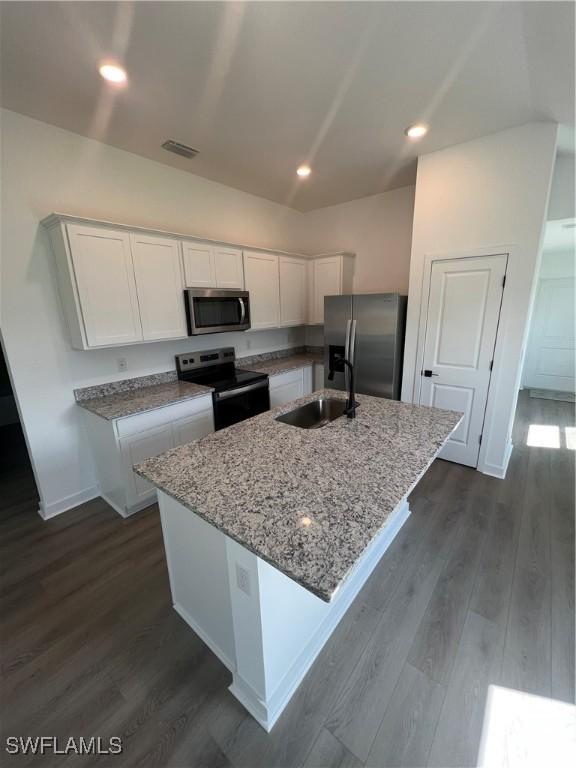 726 Goldrock Rd, Lehigh Acres, FL 33974 - kitchen featuring appliances with stainless steel finishes, white cabinetry, light stone counters, dark wood finished floors, and recessed lighting