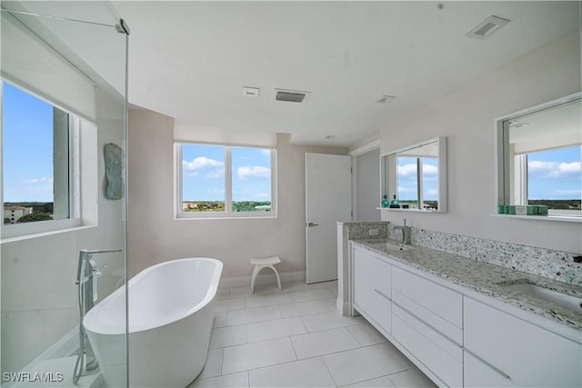 7515 Pelican Bay Blvd Unit 8A, Naples, FL 34108 - full bathroom with plenty of natural light, a freestanding tub, double vanity, and tile patterned flooring