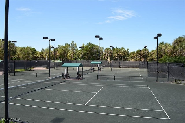 24320 Sandpiper Isle Way Unit 202, Bonita Springs, FL 34134 - view of tennis court featuring view of wooded area