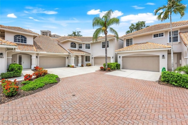 24320 Sandpiper Isle Way Unit 202, Bonita Springs, FL 34134 - mediterranean / spanish-style home featuring decorative driveway, stucco siding, a garage, and a tile roof