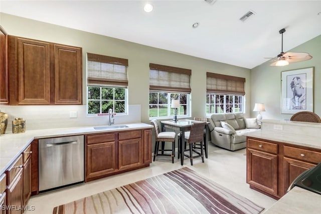 24320 Sandpiper Isle Way Unit 202, Bonita Springs, FL 34134 - kitchen with stainless steel dishwasher, light countertops, ceiling fan, light tile patterned floors, and brown cabinetry