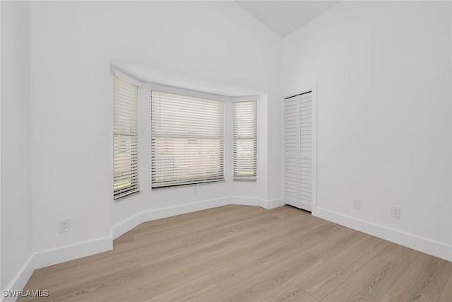 221 Saint James Way, Naples, FL 34104 - empty room with light wood-style flooring and plenty of natural light
