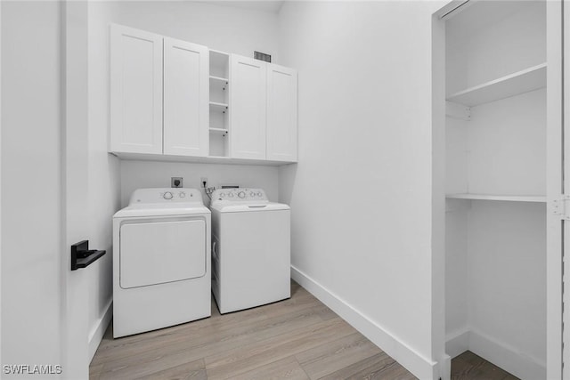 221 Saint James Way, Naples, FL 34104 - laundry area featuring cabinet space, washing machine and dryer, and light wood-style floors
