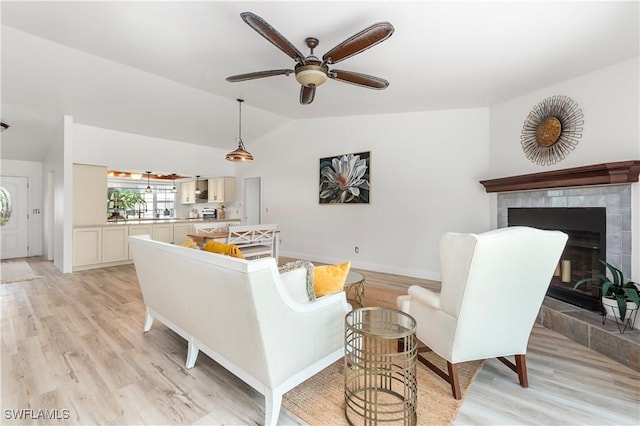 6340 P G A Dr, North Fort Myers, FL 33917 - living room featuring vaulted ceiling, light wood-type flooring, a ceiling fan, and a fireplace