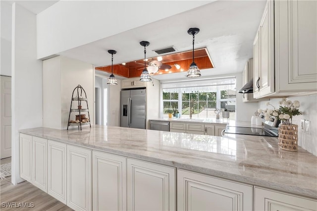 6340 P G A Dr, North Fort Myers, FL 33917 - kitchen featuring stainless steel appliances, light stone countertops, wall chimney exhaust hood, and decorative light fixtures