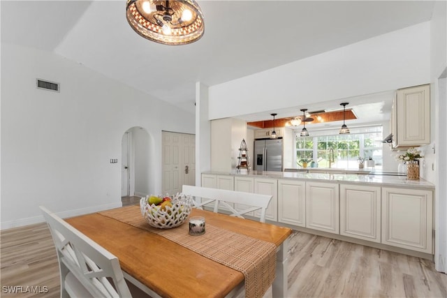 6340 P G A Dr, North Fort Myers, FL 33917 - dining space with arched walkways, light wood-style flooring, lofted ceiling, and a chandelier