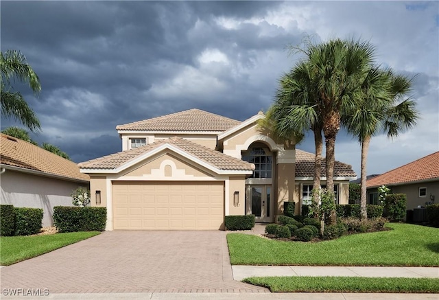 9227 Independence Way, Fort Myers, FL 33913 - mediterranean / spanish-style house featuring decorative driveway, stucco siding, an attached garage, and a tile roof