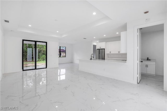 3644 35th Ave NE, Naples, FL 34120 - unfurnished living room with a tray ceiling, light marble finish flooring, and recessed lighting
