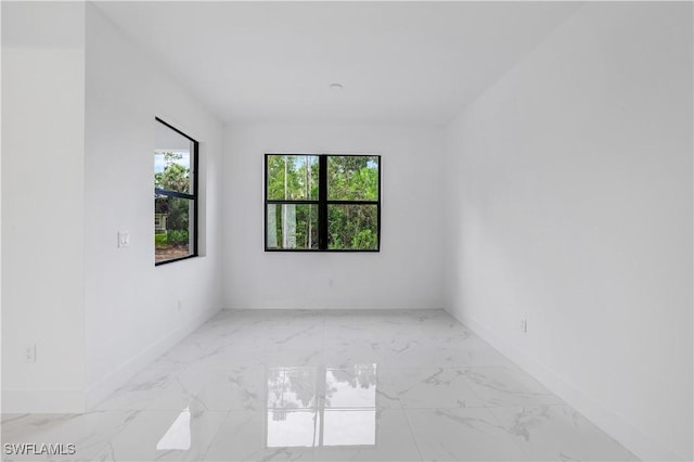 3644 35th Ave NE, Naples, FL 34120 - spare room with marble look tile flooring and baseboards