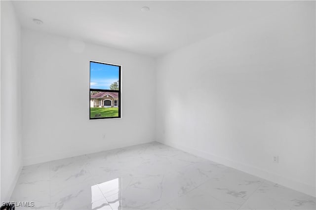 3644 35th Ave NE, Naples, FL 34120 - empty room featuring marble look tiles and a smoke detector