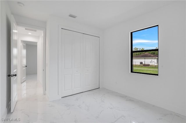 3644 35th Ave NE, Naples, FL 34120 - unfurnished bedroom with light marble finish flooring and a closet