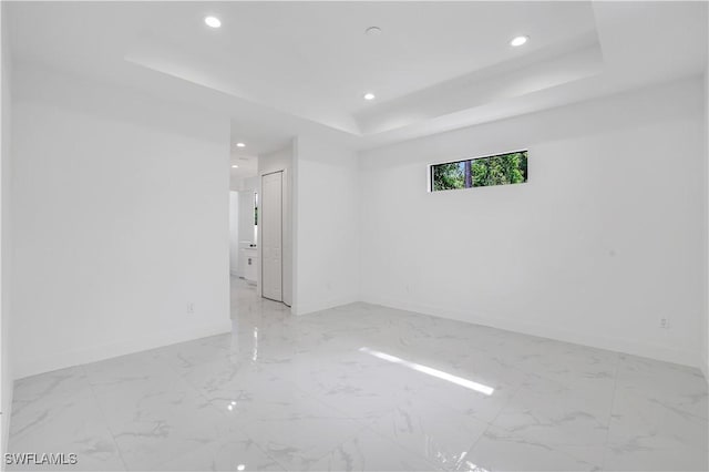3644 35th Ave NE, Naples, FL 34120 - empty room featuring a raised ceiling, recessed lighting, and light marble finish flooring