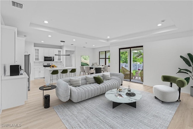 1061 Sunrise Blvd, Lehigh Acres, FL 33974 - living room with a tray ceiling, recessed lighting, and light wood-type flooring
