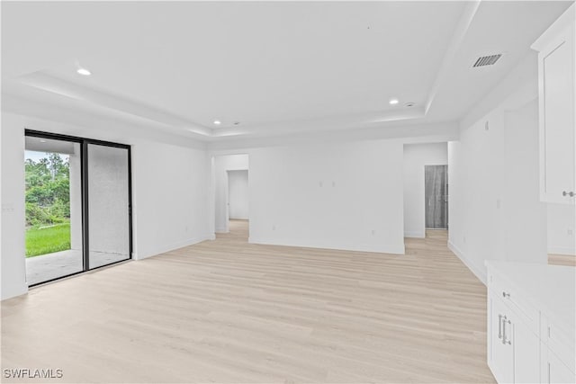 1061 Sunrise Blvd, Lehigh Acres, FL 33974 - empty room with a raised ceiling, light wood-style floors, and recessed lighting