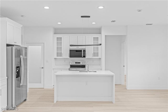 1061 Sunrise Blvd, Lehigh Acres, FL 33974 - kitchen featuring white electric range oven, stainless steel fridge, light wood finished floors, light countertops, and glass insert cabinets