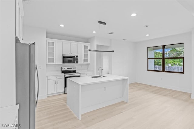 1061 Sunrise Blvd, Lehigh Acres, FL 33974 - kitchen with stainless steel appliances, light wood-type flooring, light countertops, white cabinetry, and recessed lighting