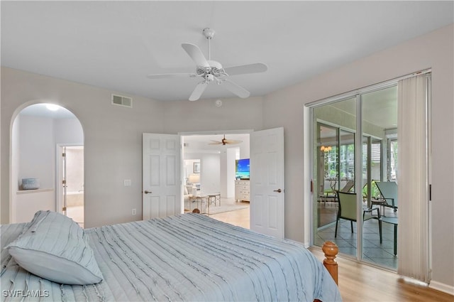 7120 Timberland Cir Unit 101, Naples, FL 34109 - bedroom with access to exterior, light wood-style floors, arched walkways, ceiling fan, and connected bathroom