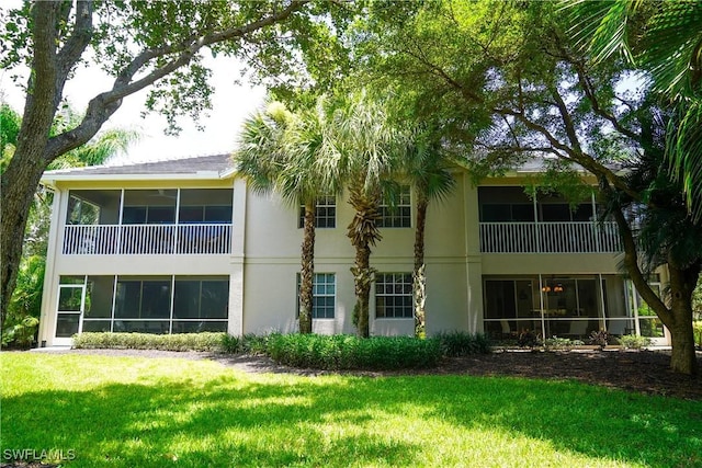 7120 Timberland Cir Unit 101, Naples, FL 34109 - back of house with stucco siding, a yard, and a sunroom