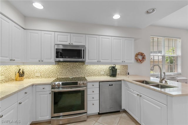 7120 Timberland Cir Unit 101, Naples, FL 34109 - kitchen with appliances with stainless steel finishes, tasteful backsplash, a peninsula, white cabinets, and recessed lighting