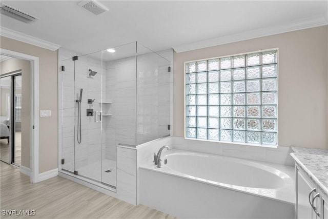 2434 Butterfly Palm Dr, Naples, FL 34119 - ensuite bathroom featuring a garden tub, crown molding, a stall shower, wood finished floors, and vanity