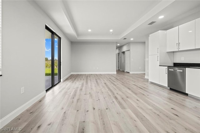 3006 72nd St W, Lehigh Acres, FL 33971 - unfurnished living room featuring light wood-type flooring, recessed lighting, and a tray ceiling