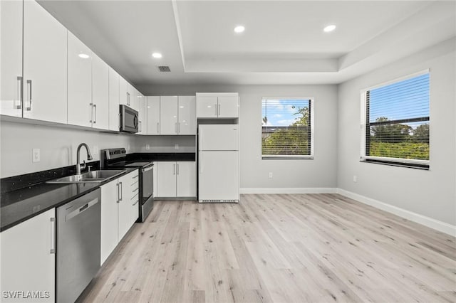 3006 72nd St W, Lehigh Acres, FL 33971 - kitchen with stainless steel appliances, a tray ceiling, light wood-type flooring, recessed lighting, and white cabinetry