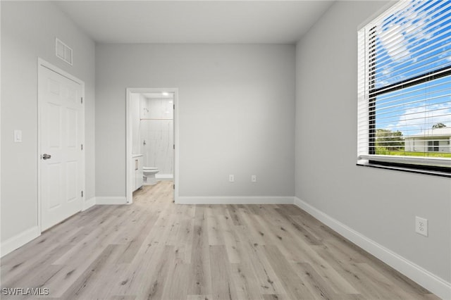 3006 72nd St W, Lehigh Acres, FL 33971 - unfurnished bedroom featuring light wood-style floors and connected bathroom