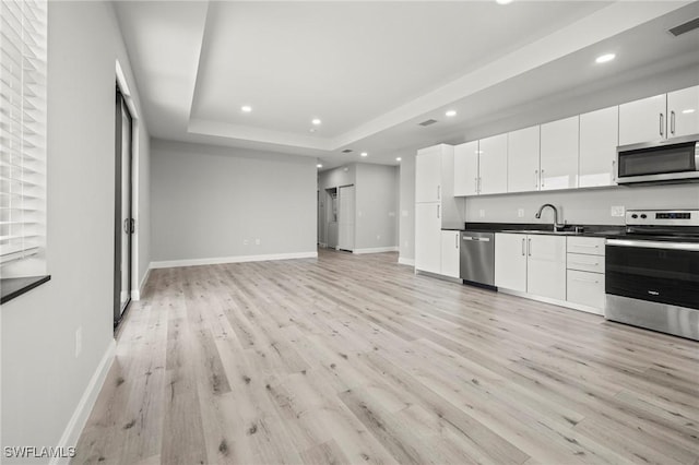3006 72nd St W, Lehigh Acres, FL 33971 - kitchen featuring appliances with stainless steel finishes, light wood-style flooring, recessed lighting, dark countertops, and white cabinets