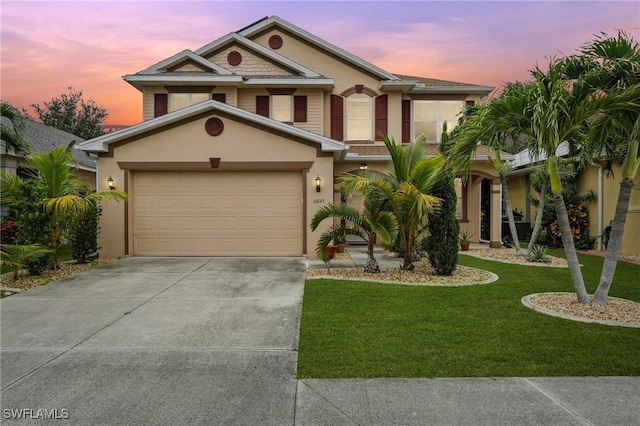 10043 Winding River Rd, Punta Gorda, FL 33950 - view of front of home with stucco siding, driveway, a front yard, and a garage