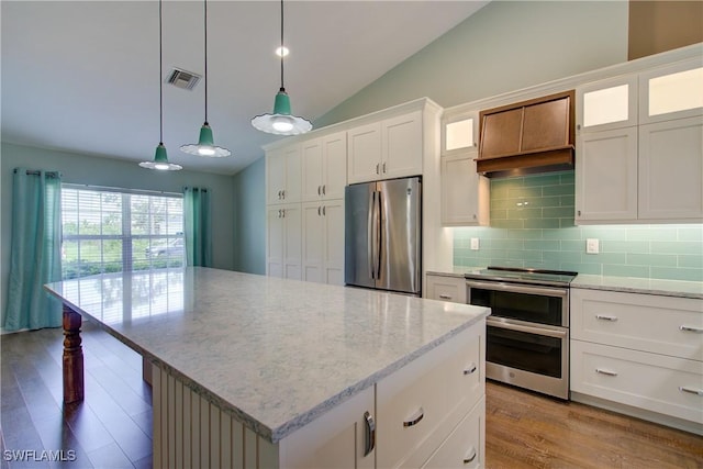 2116 NW 24th Ave, Cape Coral, FL 33993 - kitchen with appliances with stainless steel finishes, wood finished floors, lofted ceiling, decorative backsplash, and a center island