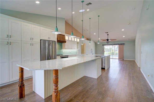 2116 NW 24th Ave, Cape Coral, FL 33993 - kitchen featuring appliances with stainless steel finishes, a peninsula, wood finished floors, custom exhaust hood, and a ceiling fan