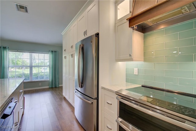 2116 NW 24th Ave, Cape Coral, FL 33993 - kitchen with appliances with stainless steel finishes, exhaust hood, white cabinets, decorative backsplash, and light stone counters