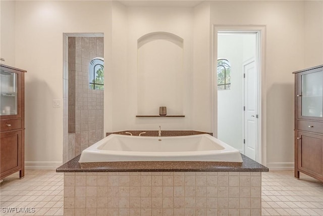 3917 La Vida Way, Cape Coral, FL 33993 - bathroom featuring a garden tub, tile patterned floors, and plenty of natural light