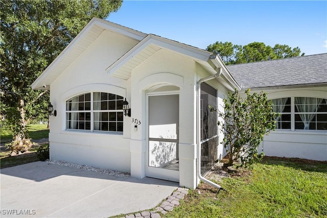 3715 41st Ave NE, Naples, FL 34120 - doorway to property with roof with shingles and a patio area