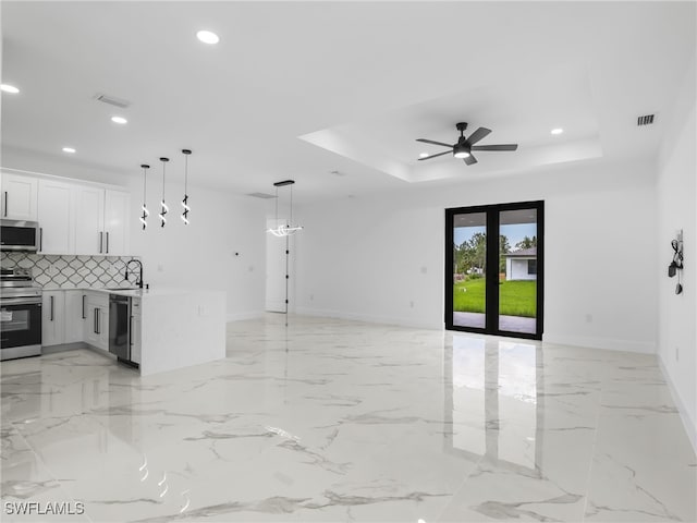 3219 43rd St W, Lehigh Acres, FL 33971 - unfurnished living room with a raised ceiling, recessed lighting, a ceiling fan, and light marble finish floors