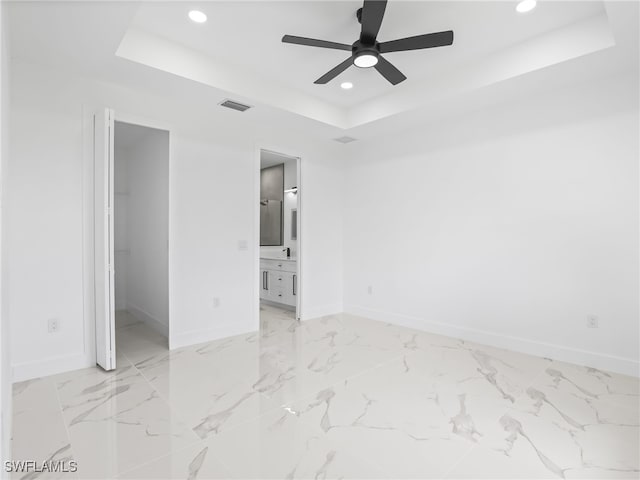3219 43rd St W, Lehigh Acres, FL 33971 - unfurnished bedroom featuring a tray ceiling, recessed lighting, a walk in closet, a ceiling fan, and ensuite bathroom