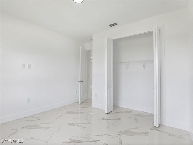 3219 43rd St W, Lehigh Acres, FL 33971 - unfurnished bedroom featuring a closet and light marble finish floors