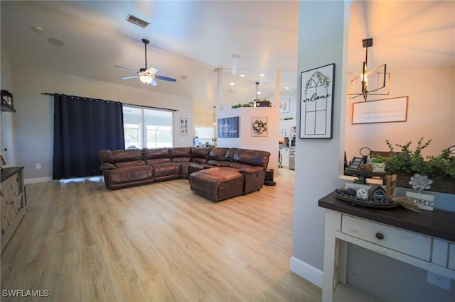 823 Portland St E, Lehigh Acres, FL 33974 - living area featuring light wood finished floors, a ceiling fan, high vaulted ceiling, and a chandelier