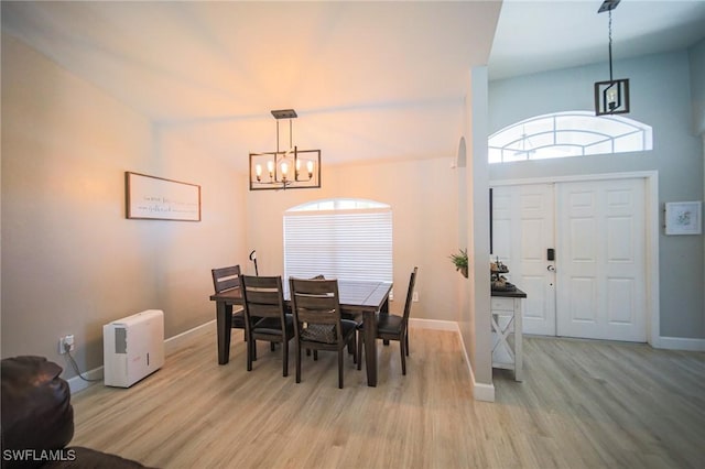 823 Portland St E, Lehigh Acres, FL 33974 - dining room featuring a chandelier, light wood-type flooring, and plenty of natural light