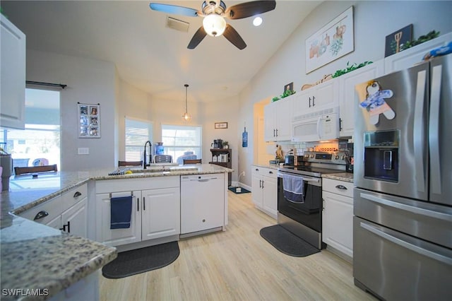 823 Portland St E, Lehigh Acres, FL 33974 - kitchen with appliances with stainless steel finishes, white cabinets, ceiling fan, lofted ceiling, and light wood-type flooring