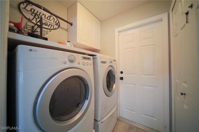 823 Portland St E, Lehigh Acres, FL 33974 - washroom featuring cabinet space, washer and clothes dryer, and light wood-style floors