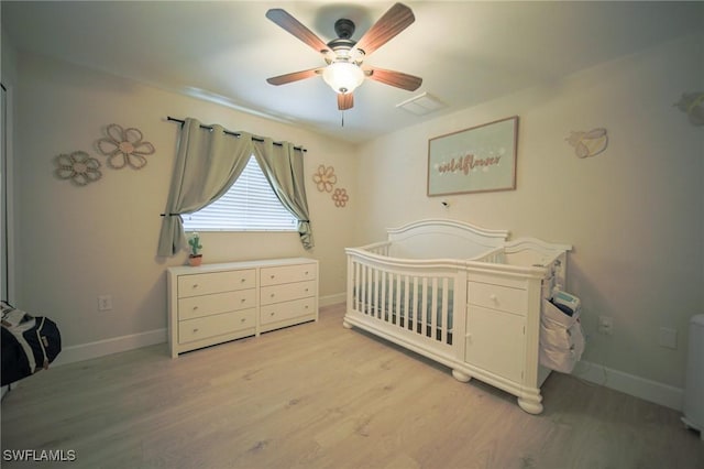 823 Portland St E, Lehigh Acres, FL 33974 - bedroom with light wood-style flooring, a nursery area, and ceiling fan