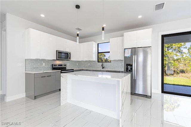 3306 40th St W, Lehigh Acres, FL 33971 - kitchen featuring appliances with stainless steel finishes, modern cabinets, decorative backsplash, a center island, and recessed lighting