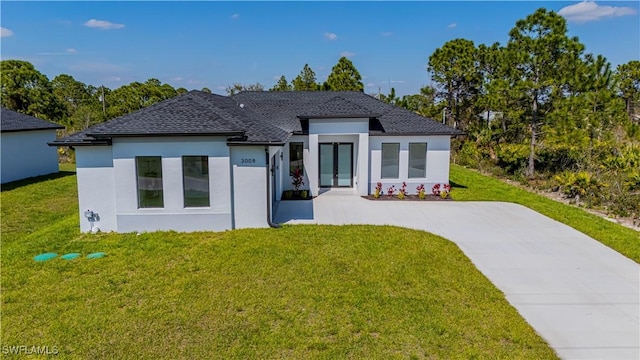 3306 40th St W, Lehigh Acres, FL 33971 - modern home with a front yard, stucco siding, driveway, and roof with shingles