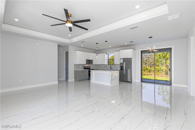3306 40th St W, Lehigh Acres, FL 33971 - unfurnished living room with a tray ceiling, light marble finish flooring, ceiling fan, recessed lighting, and a chandelier