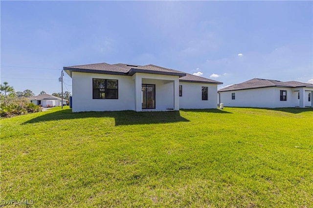 3306 40th St W, Lehigh Acres, FL 33971 - back of house with a yard and stucco siding