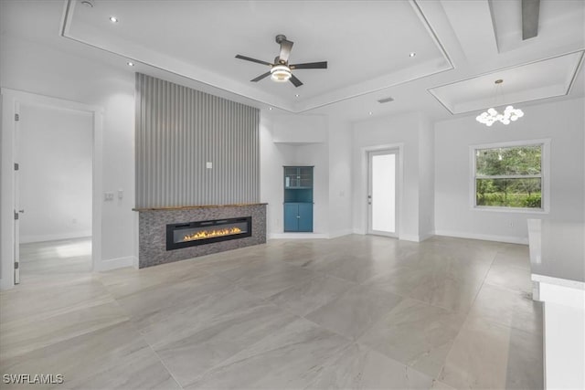 2505 43rd St SW, Lehigh Acres, FL 33976 - unfurnished living room featuring a raised ceiling, a glass covered fireplace, ceiling fan, recessed lighting, and a chandelier