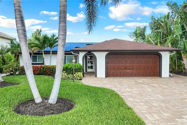 4911 Esplanade St, Bonita Springs, FL 34134 - view of front facade with stucco siding, roof mounted solar panels, a front lawn, and an attached garage