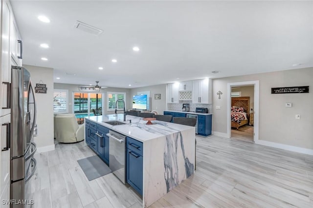4911 Esplanade St, Bonita Springs, FL 34134 - kitchen featuring stainless steel appliances, blue cabinets, a large island, white cabinets, and recessed lighting